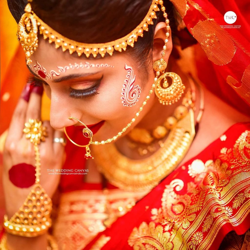 Bengali bride adorning gold wedding jewellery