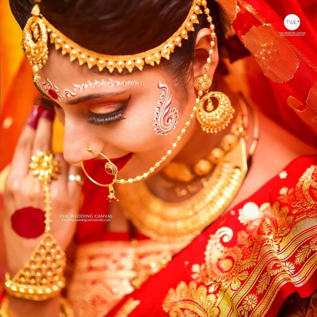 Bengali bride adorning gold wedding jewellery