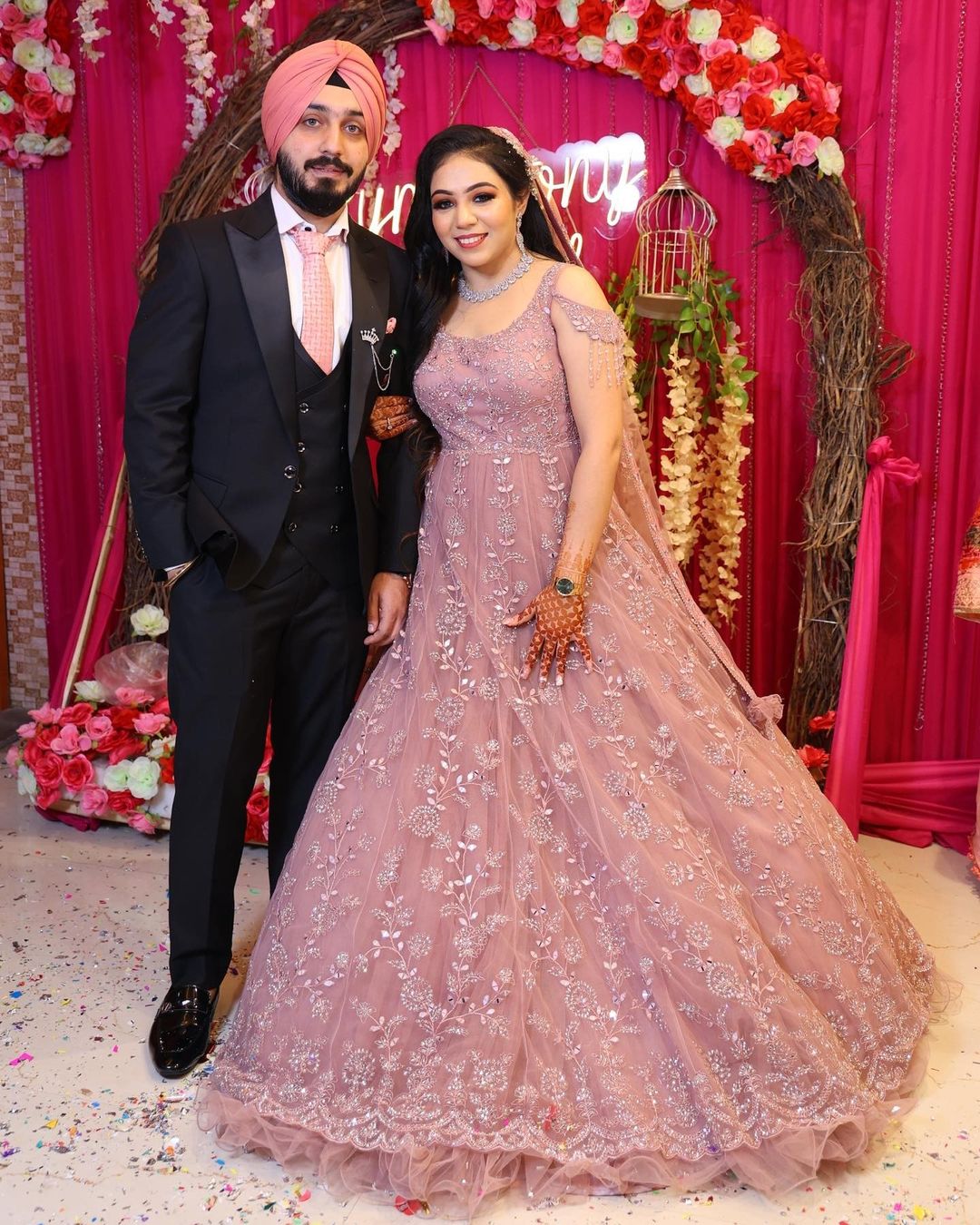 bride in engagement gown with dupatta and groom in black tuxedo 