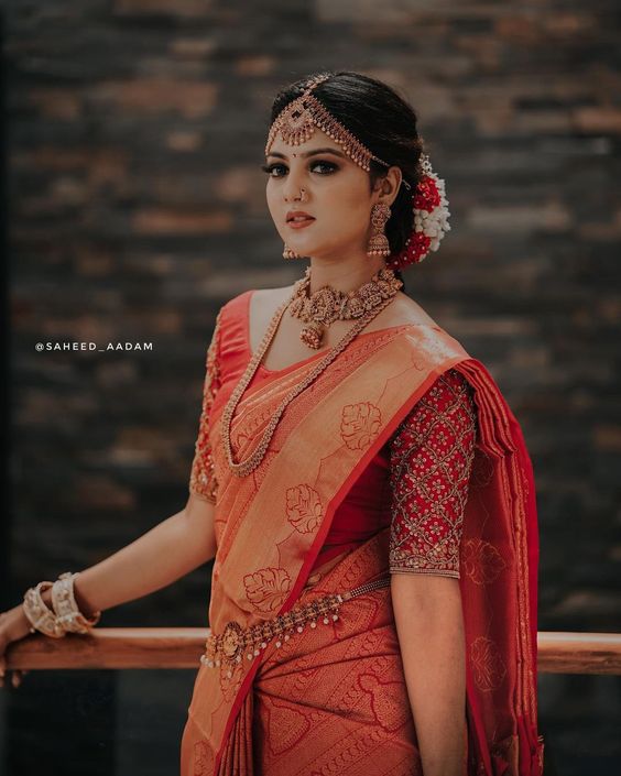 Simple south Indian saree look with bride in red South Indian wedding saree and bun hairstyle