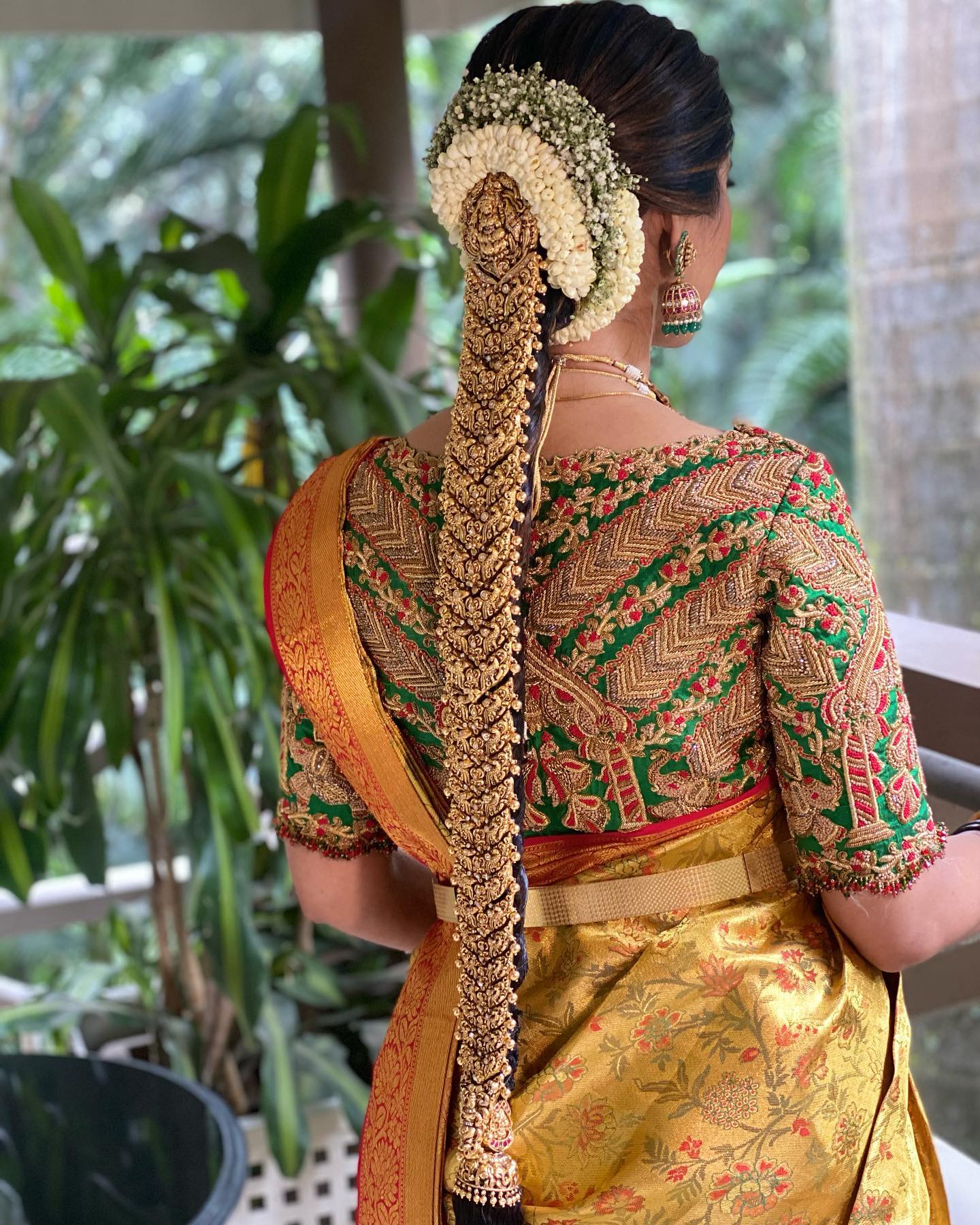 south indian bridal jada hairstyle with golden kanjeevaram saree