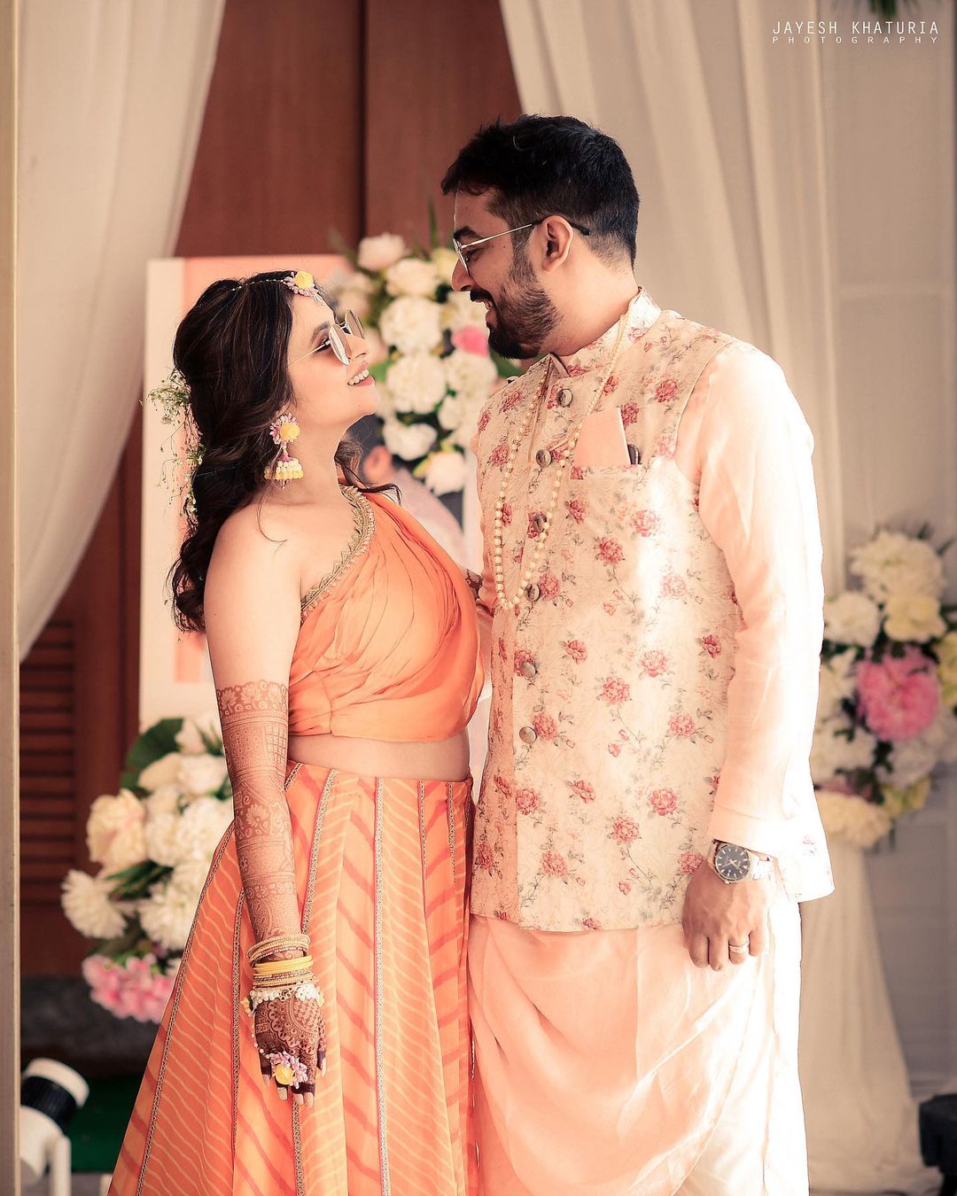 Photo of Bride and groom posing contrasting on mehendi