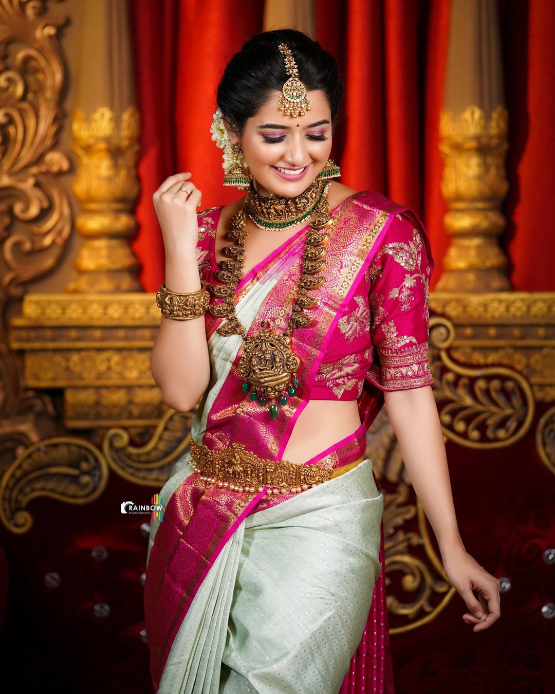south indian actress wedding getup in white and pink saree and bun hairstyle