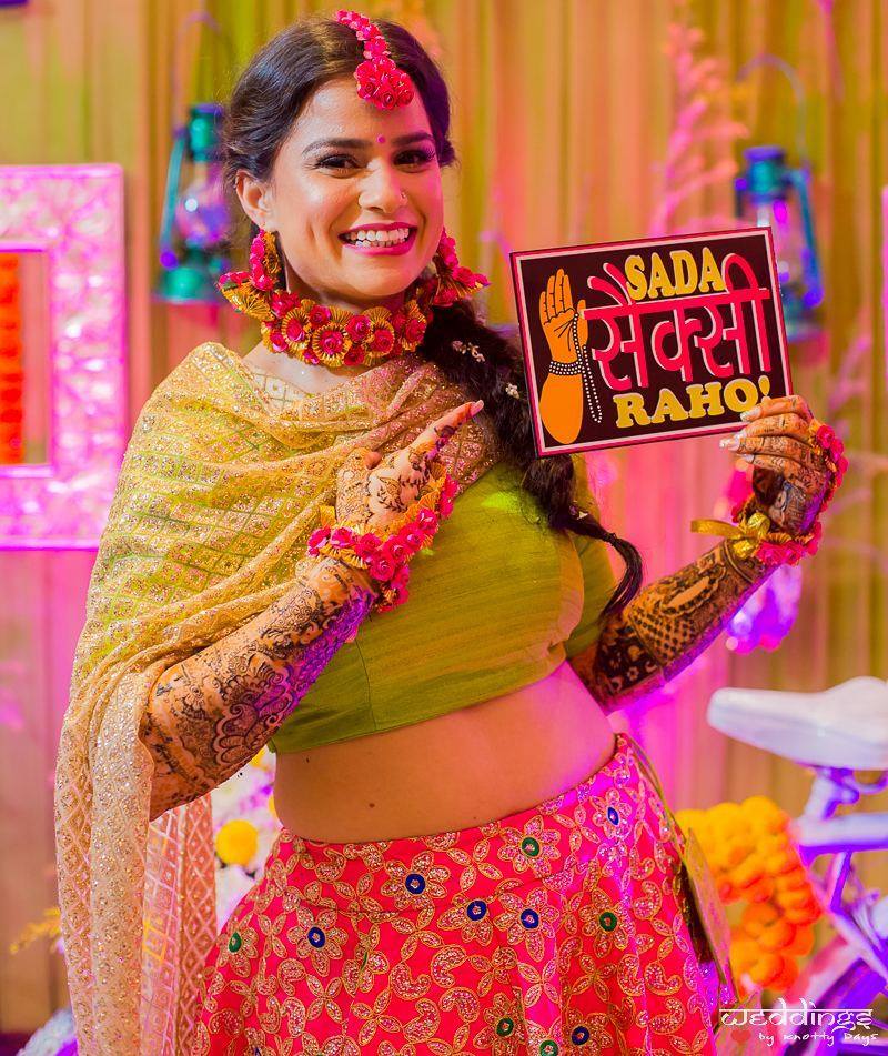 bride posing with prop on her mehendi ceremony