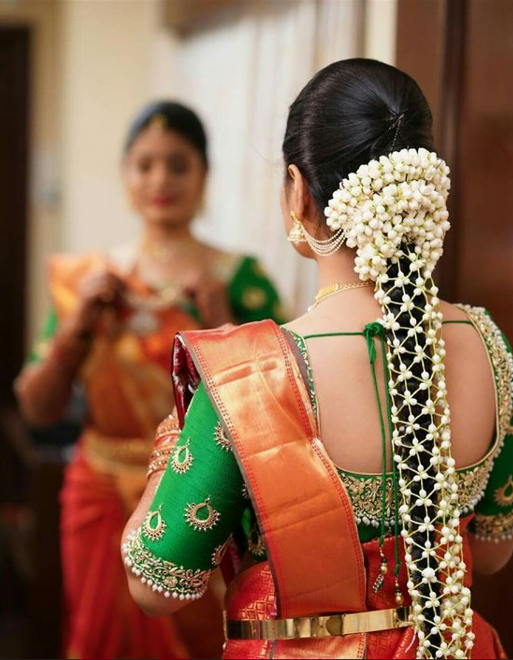 south indian bridal hairdo with netted gajra braid