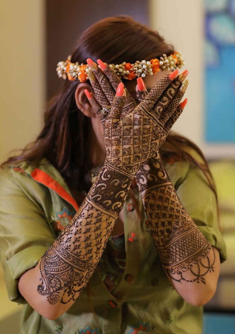 hands covering face mehndi pose for bride