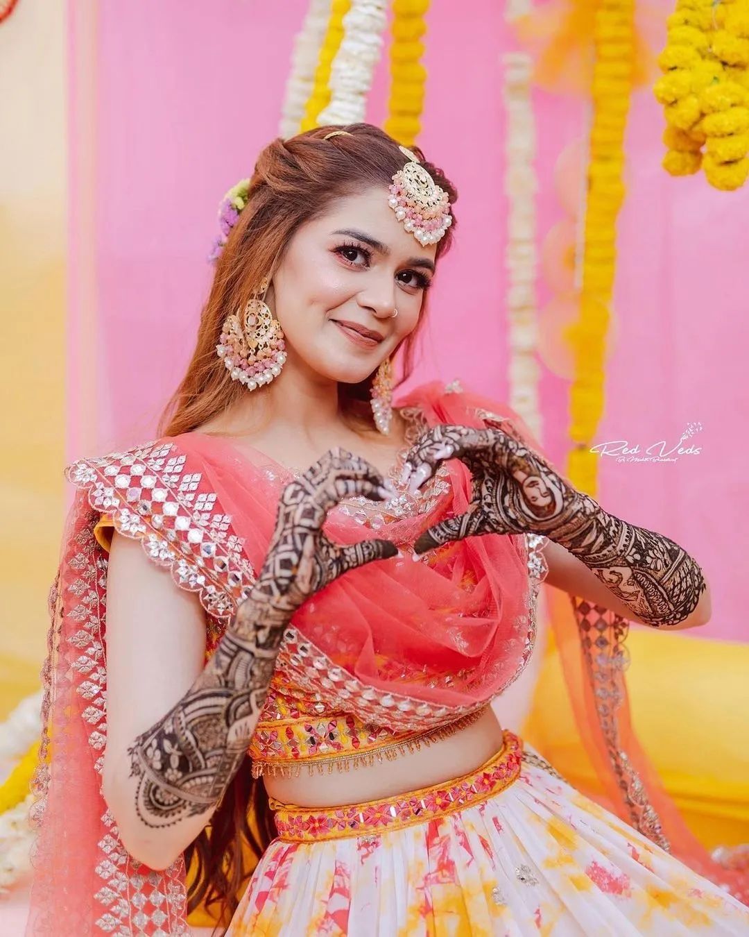 bride making a heart with mehndi hands