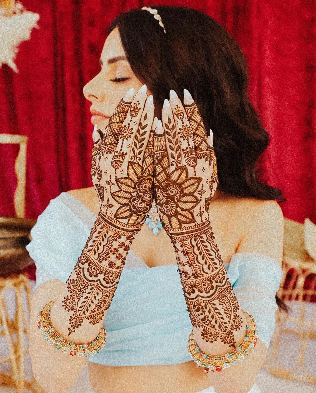 bride joining her mehndi hands for photoshoot