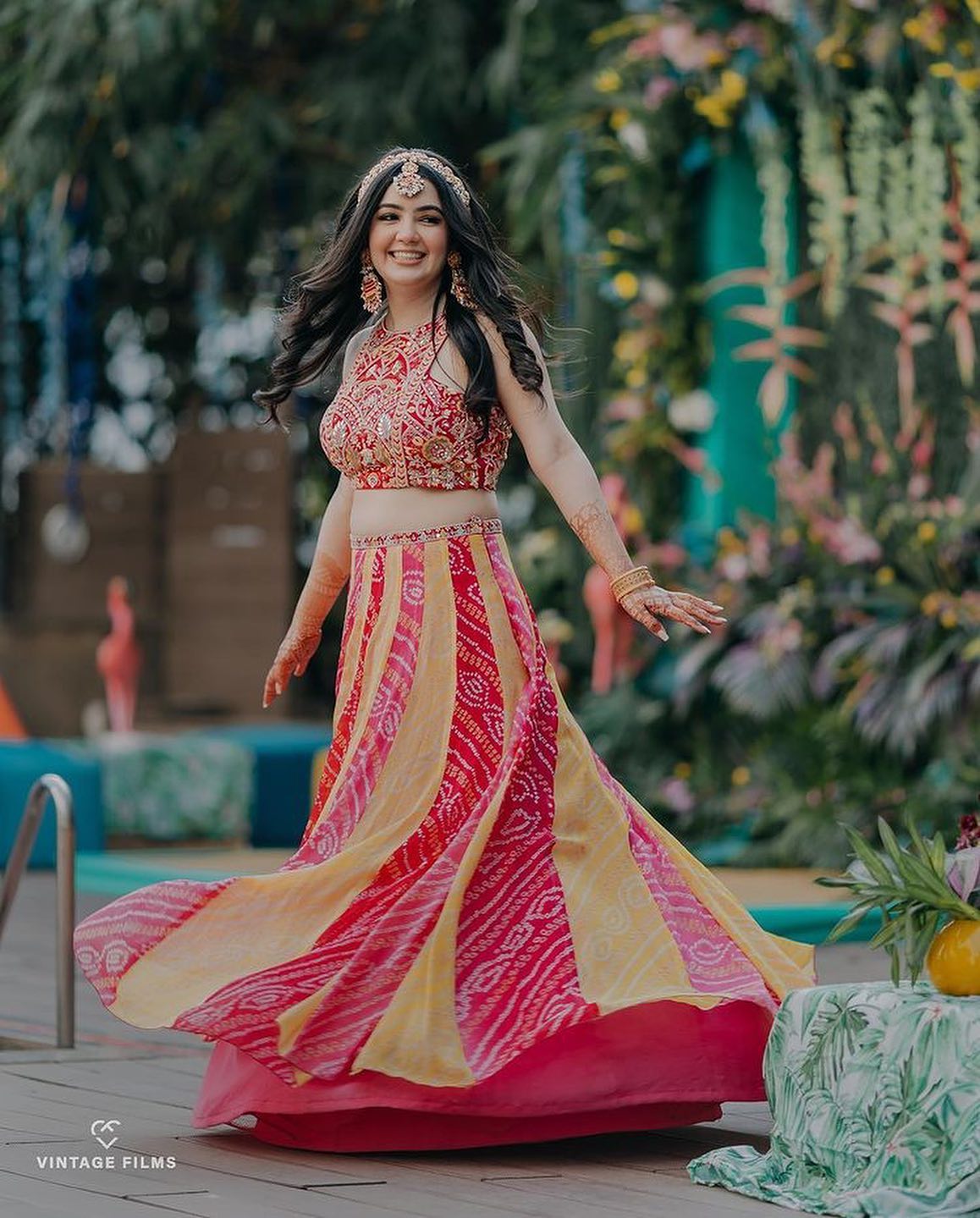 bride wearing red and yellow bandhani skirt top on haldi