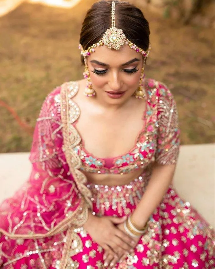 bride wearing beautiful pink floral matha patti 