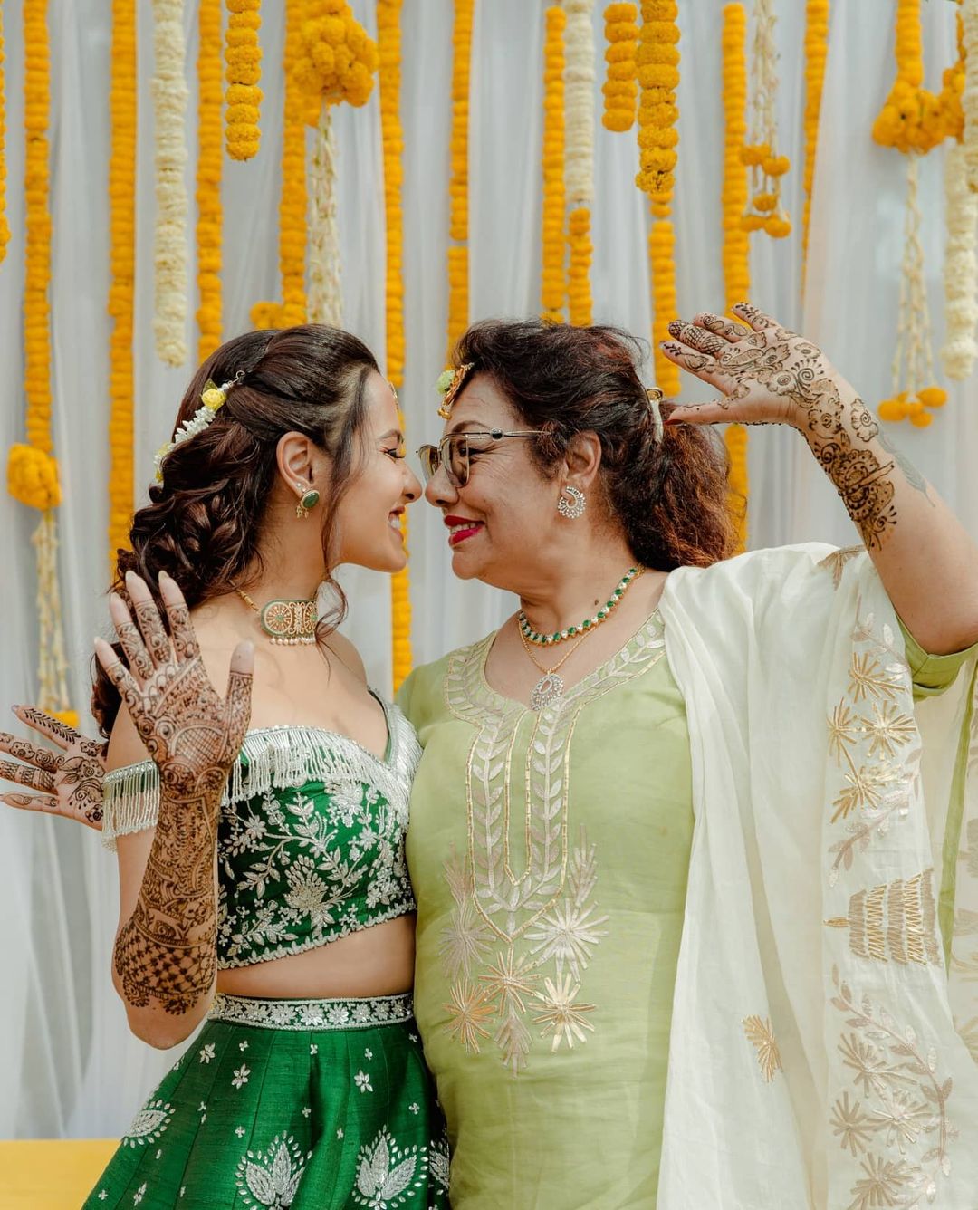 bride posing with her mother on mehndi ceremony