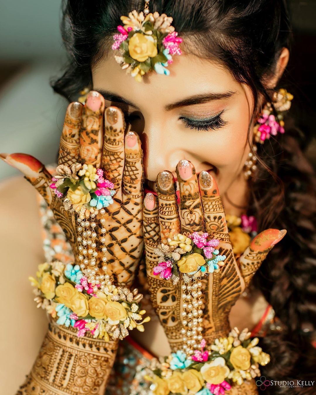 bridal pose with floral jewelry and mehendi