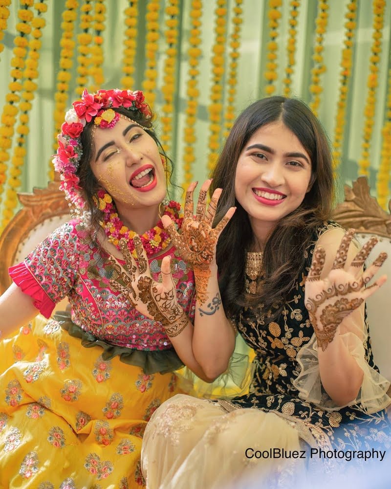 bride posing with bridesmaid on her mehndi