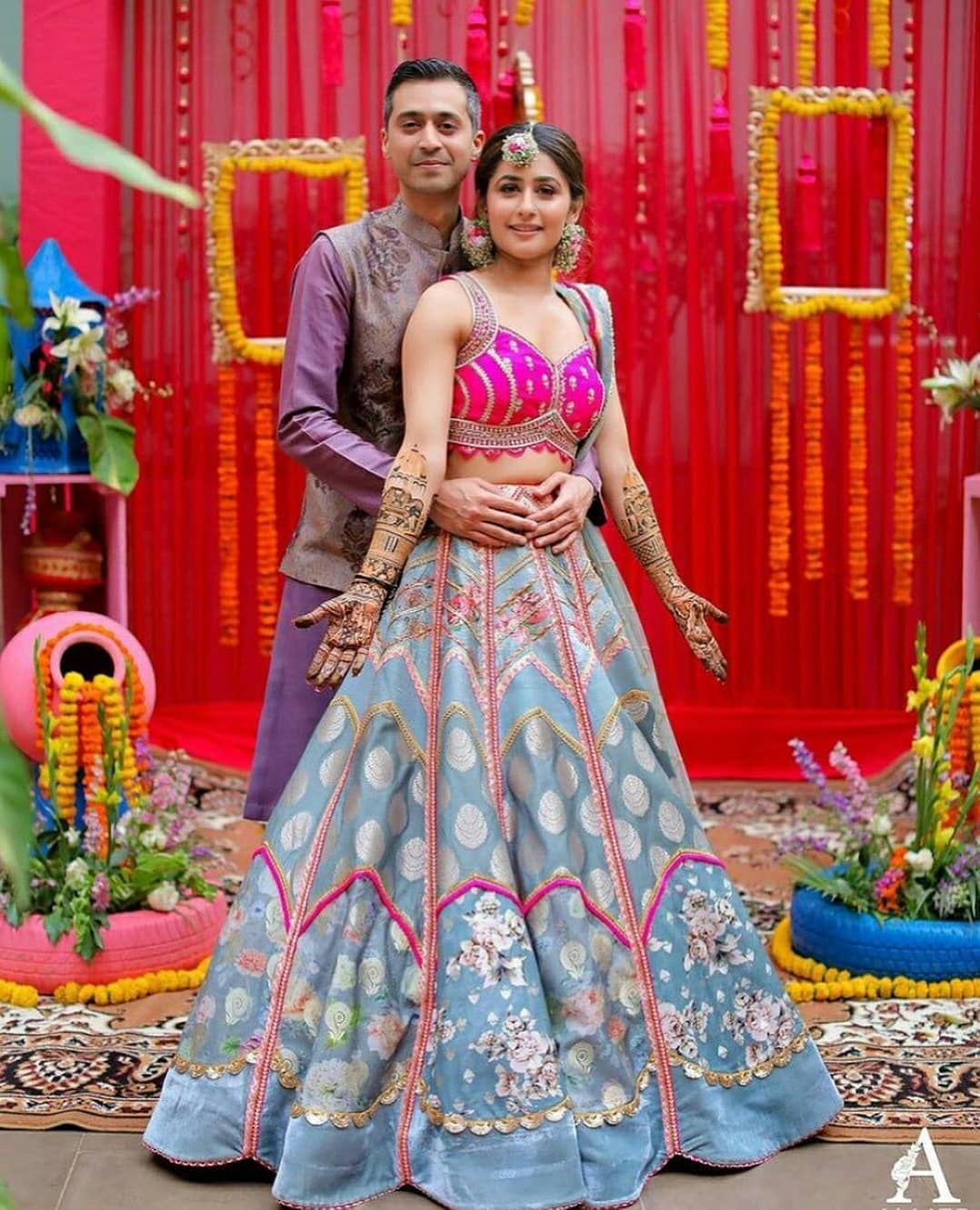 standing bride and groom pose for mehndi photoshoot