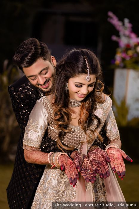 bride and groom posing with their mehndi