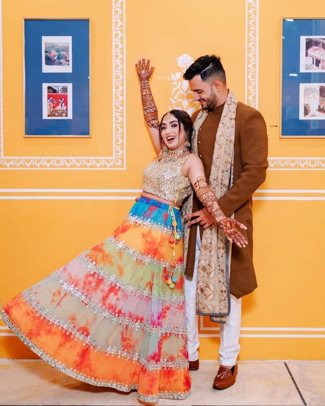 bride posing with her groom on mehndi