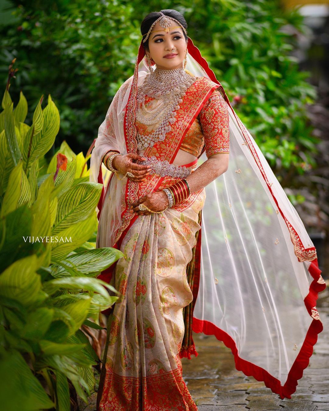 modern south indian bride wearing red and cream saree with dupatta and diamond jewellery 