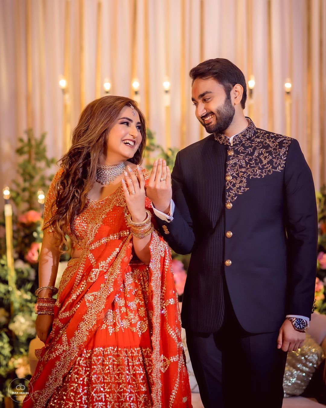 couple in orange black colour-coordinating engagement dress