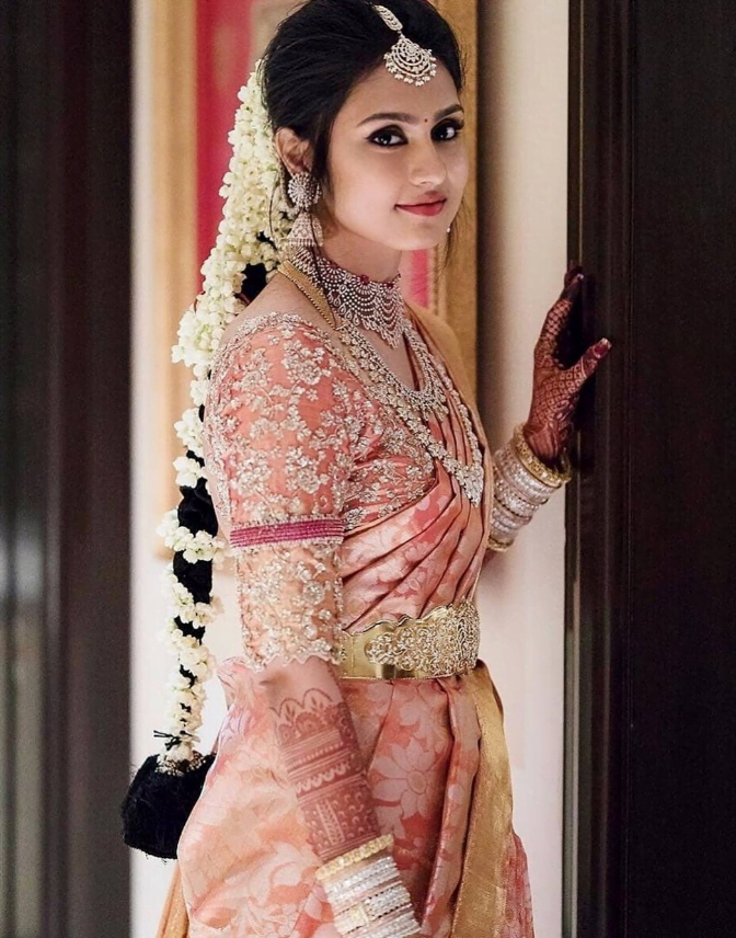 simple and traditional south indian bride in pink silk saree and gajra hairstyle