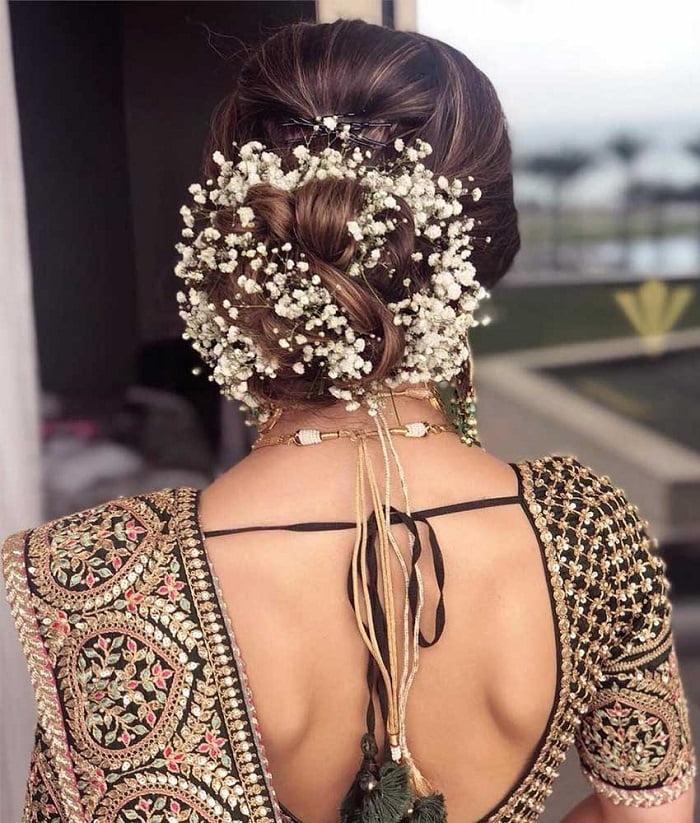 Photo of Curly Bun Bridal Hairstyle with Red Flowers on Side