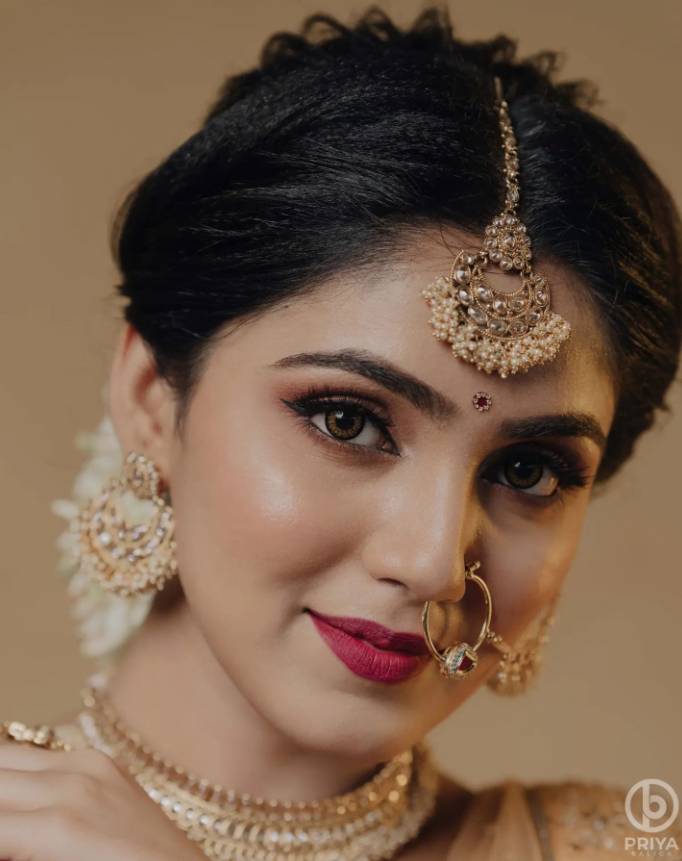 south indian bridal look with bold lips and maang tikka hairstyle