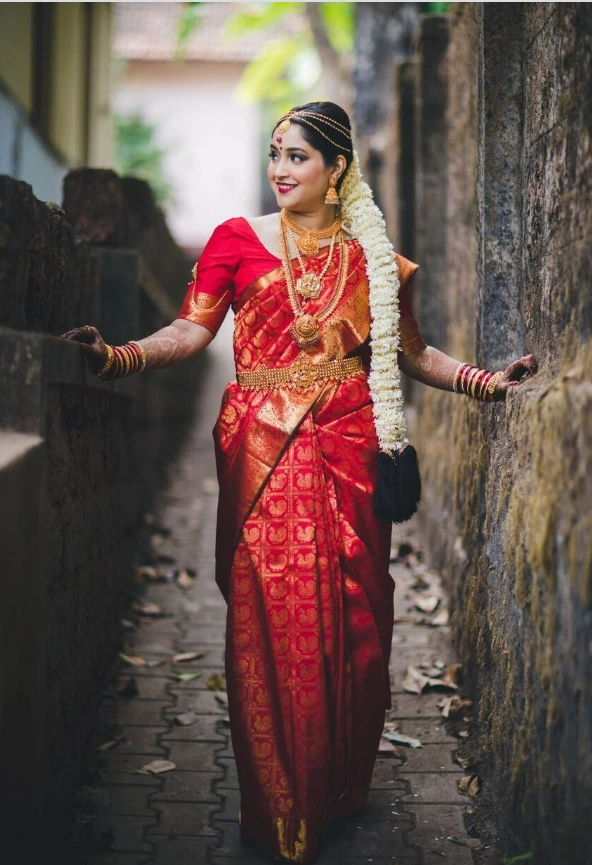 traditional south indian bride wearing red silk saree and poola jada hairstyle