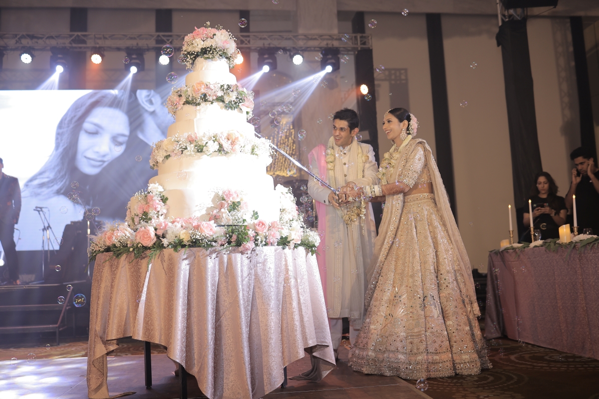 Kashish and Aseem during cake cutting ceremony at their Thailand beach wedding