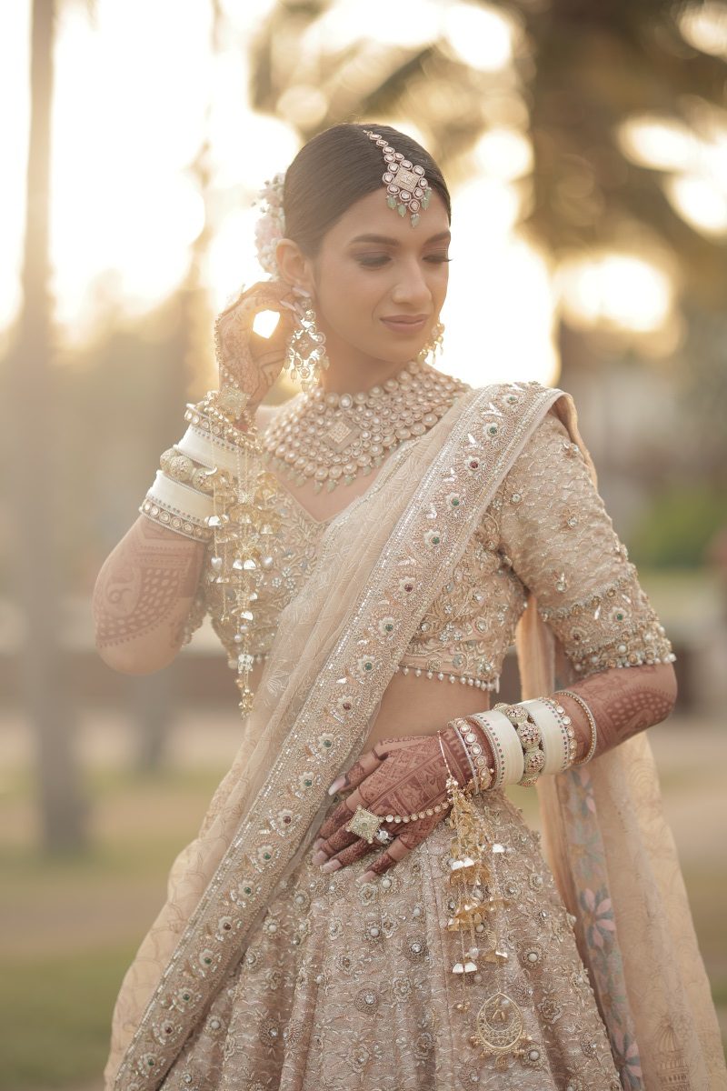 Kashish in self designed champagne gold lehenga on her beach wedding in Thailand