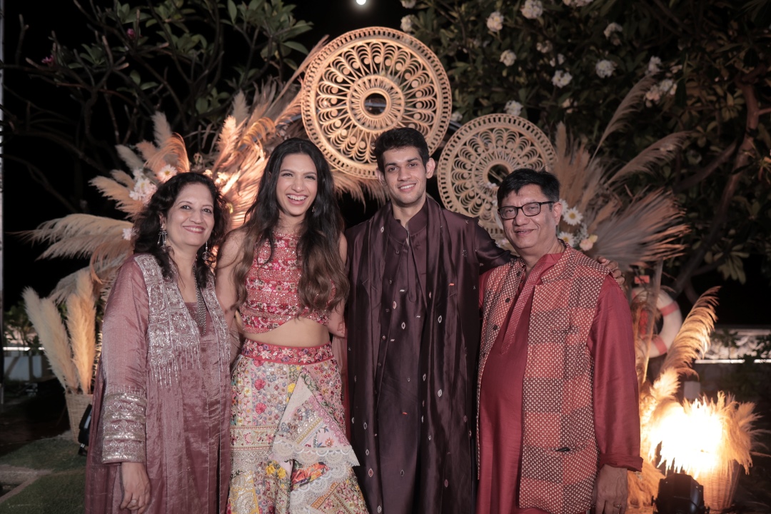Kashish and Aseem on their mehendi function posing with family on stage