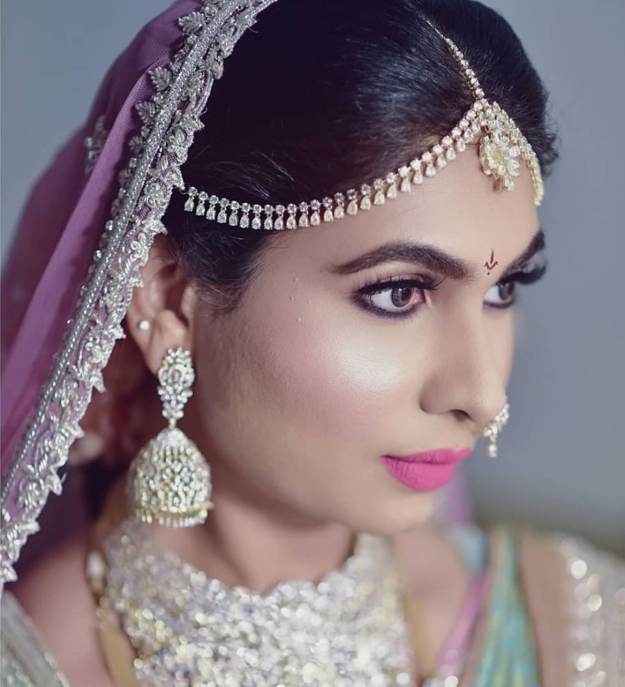 south indian makeup photo of bride with matte pink lips and kohl eyes