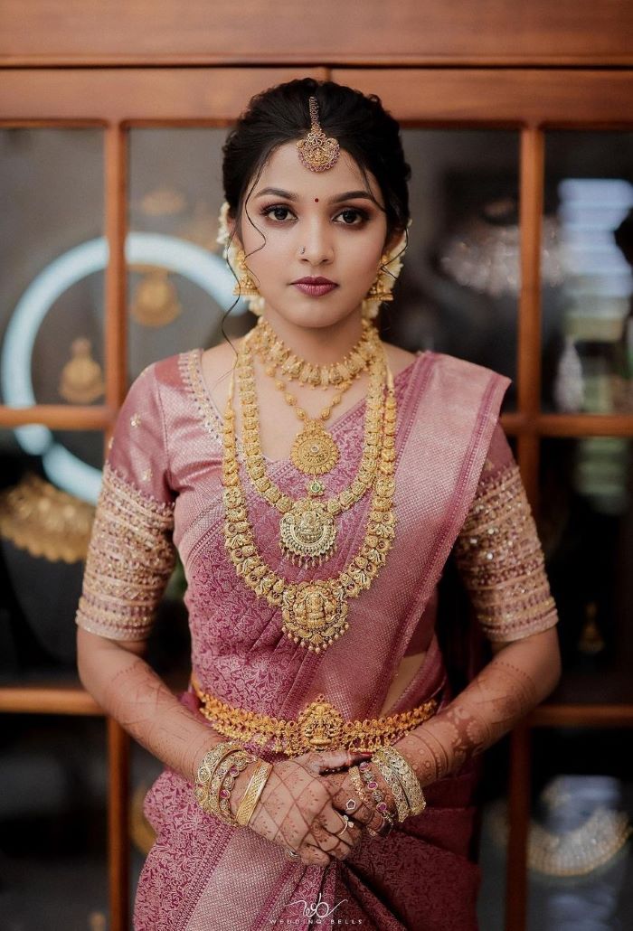 kerala bridal look indian in pink silk saree and gold jewellery