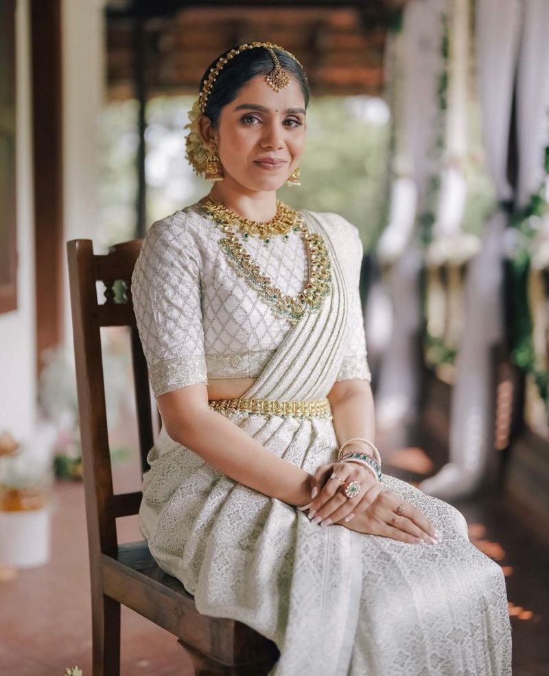 modern kerala bride wearing silver kanjeevaram saree and contrasting jewelry