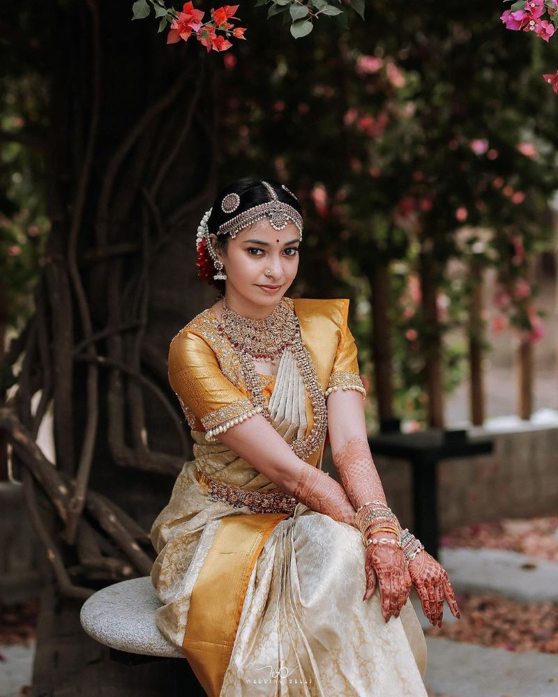 kerala bride wearing white and golden silk saree and gajra flower hairstyle 