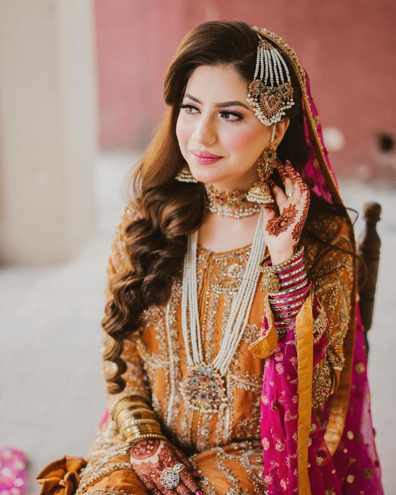 pakistani bridal hairstyle for walima featuring side swept curls and passa